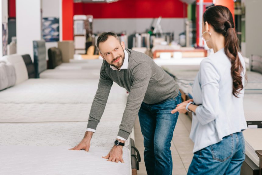 couple choosing mattress together in furniture shop