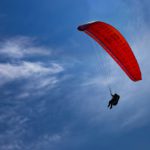 One paraglider is flying in the blue sky.