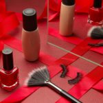 Womans festive make up with foundation, eye lashes, make-up brush and red nail polish